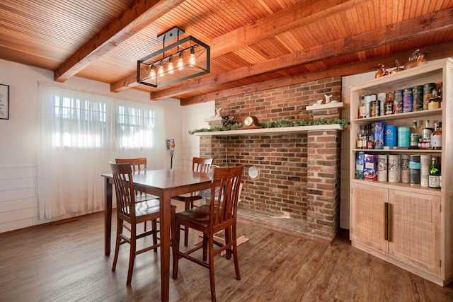 dining area with beam ceiling, wood-type flooring, brick wall, and wooden ceiling