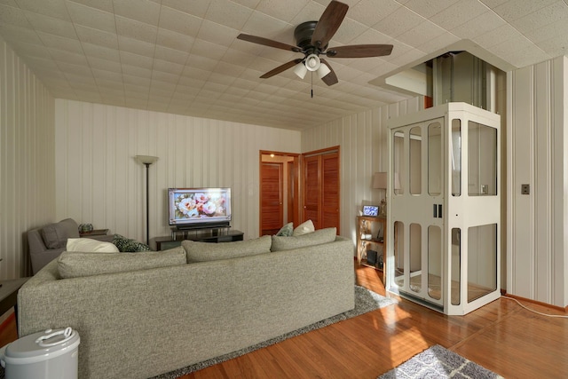 living room featuring ceiling fan and hardwood / wood-style flooring