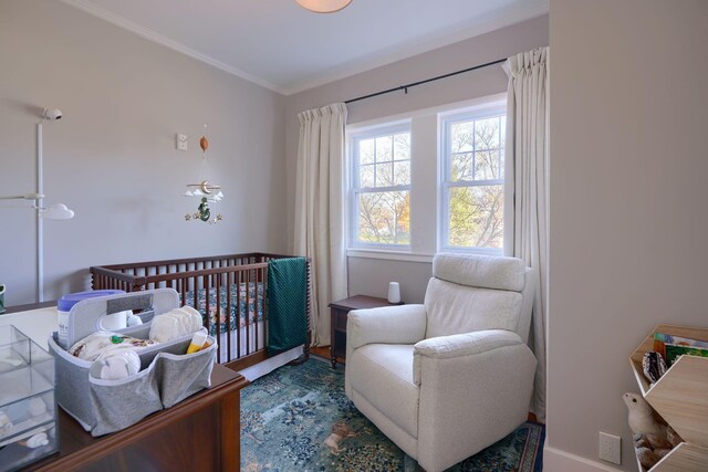 bedroom featuring hardwood / wood-style flooring, crown molding, and a nursery area