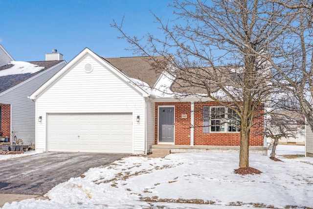 view of front of house featuring an attached garage, aphalt driveway, and brick siding