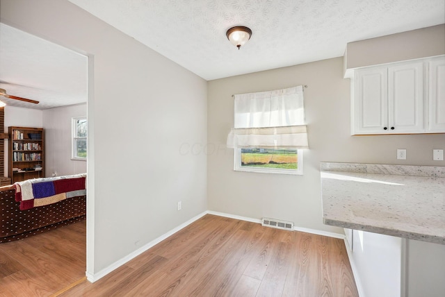 dining space featuring a textured ceiling, light hardwood / wood-style floors, and ceiling fan