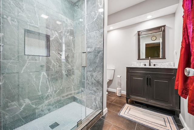 bathroom featuring tile patterned flooring, vanity, a shower with shower door, and toilet