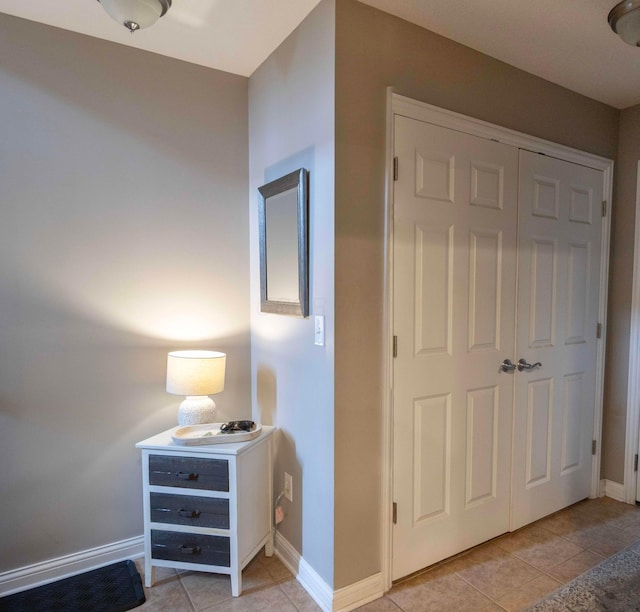 bedroom with light tile patterned flooring and a closet