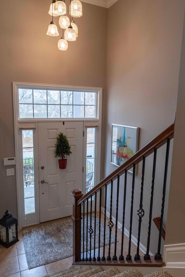 foyer with light tile patterned flooring, a high ceiling, and a chandelier