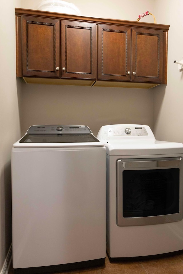 washroom featuring cabinets and independent washer and dryer