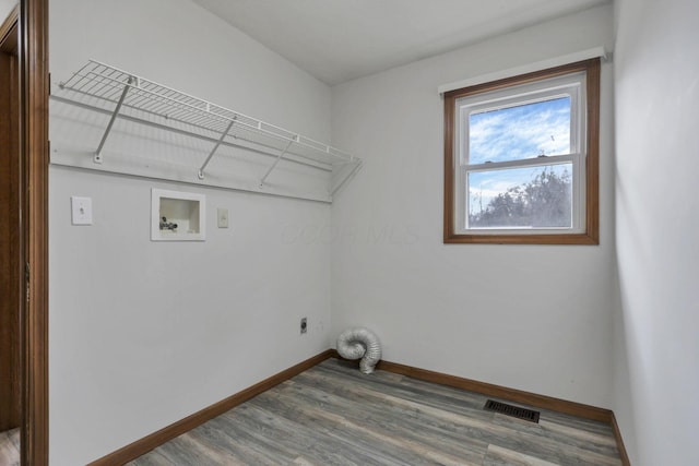 washroom with hardwood / wood-style floors, hookup for an electric dryer, and washer hookup