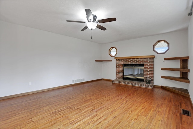 unfurnished living room featuring ceiling fan, light wood-type flooring, and a fireplace