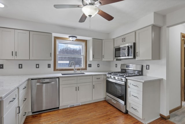 kitchen with ceiling fan, light hardwood / wood-style floors, sink, and appliances with stainless steel finishes