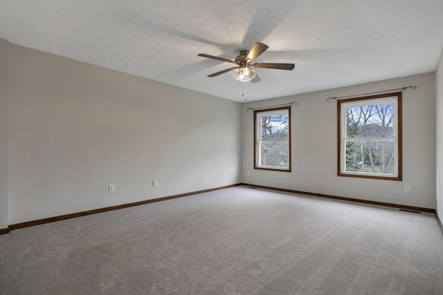 unfurnished room with light carpet, ceiling fan, and a textured ceiling