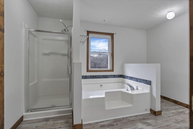 bathroom with wood-type flooring, a textured ceiling, and separate shower and tub