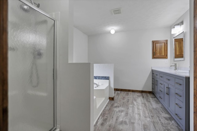 bathroom featuring vanity, independent shower and bath, a textured ceiling, and hardwood / wood-style flooring