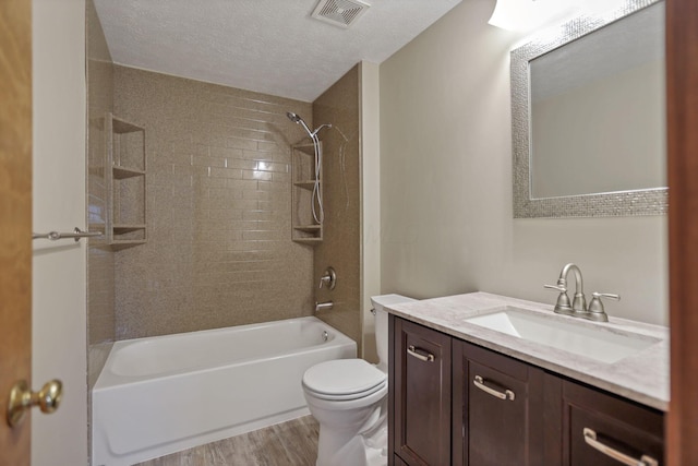 full bathroom with vanity, tiled shower / bath combo, toilet, a textured ceiling, and wood-type flooring