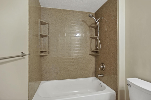 bathroom featuring a textured ceiling, toilet, and tiled shower / bath