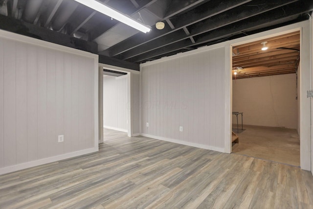 basement featuring wood-type flooring and wood walls