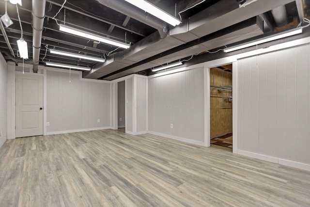 basement featuring wooden walls and hardwood / wood-style floors