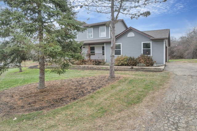 view of front of house featuring covered porch and a front lawn