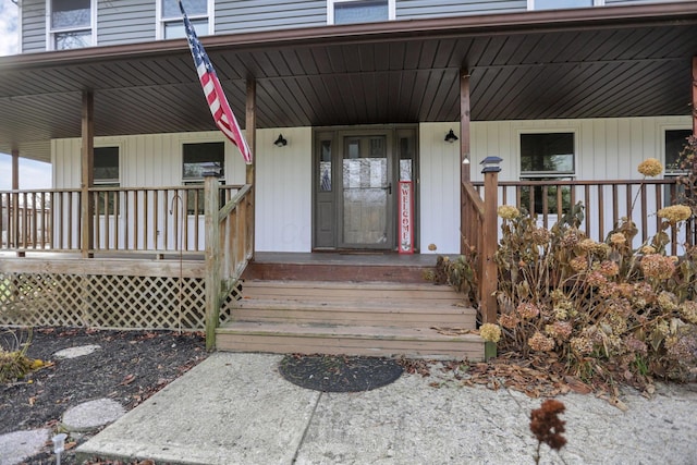 view of exterior entry featuring covered porch