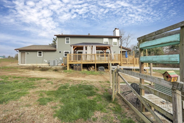 rear view of property featuring a gazebo and central AC unit