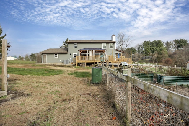 rear view of house featuring a gazebo, a yard, cooling unit, and a wooden deck