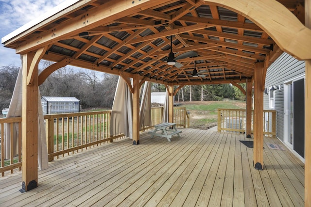 wooden deck with a gazebo, ceiling fan, and an outdoor structure