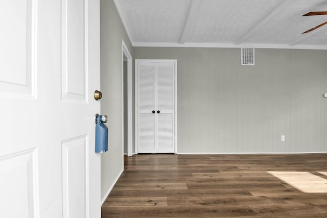 interior space featuring wood walls, dark hardwood / wood-style floors, and ceiling fan