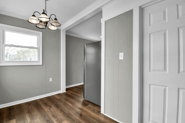 unfurnished dining area featuring a notable chandelier, crown molding, and dark wood-type flooring