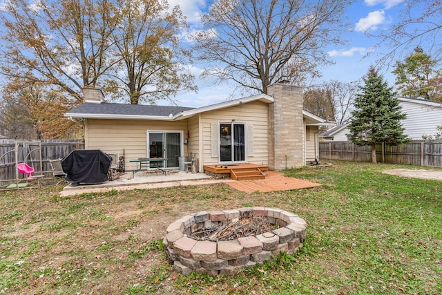 rear view of property with a patio, an outdoor fire pit, and a lawn