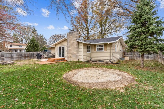 back of property with a lawn and a wooden deck