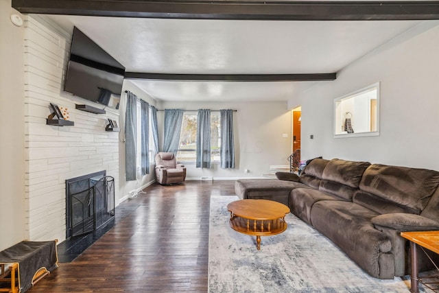 living room with beamed ceiling, a fireplace, and dark wood-type flooring