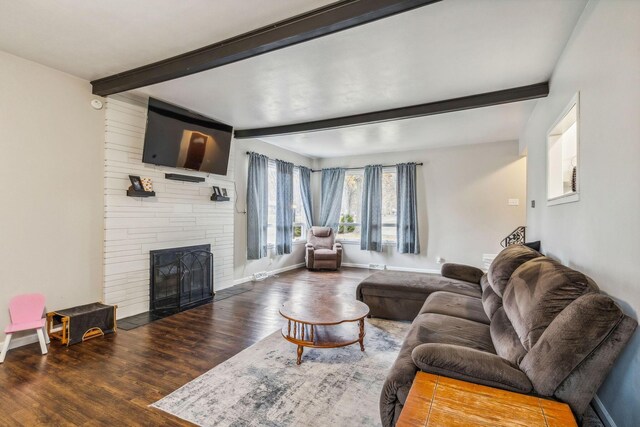 living room featuring a fireplace, beam ceiling, and dark wood-type flooring