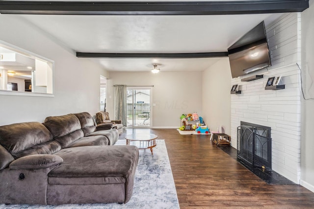 living room featuring beam ceiling, a fireplace, and dark hardwood / wood-style floors