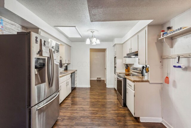 kitchen featuring white cabinets, dark hardwood / wood-style flooring, stainless steel appliances, and a textured ceiling