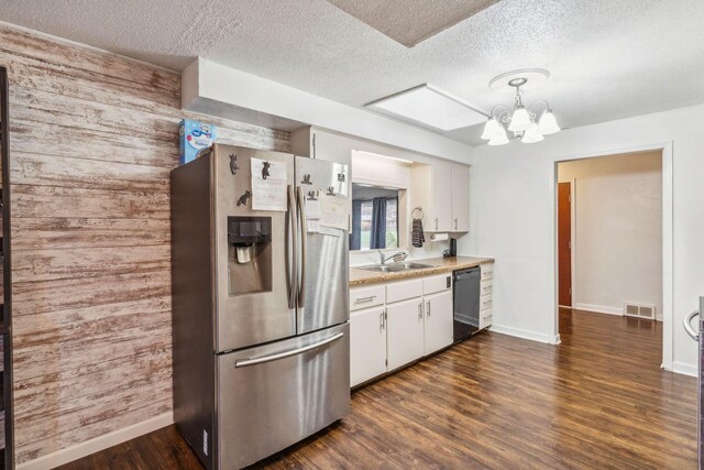 kitchen with pendant lighting, dishwasher, white cabinetry, and stainless steel refrigerator with ice dispenser