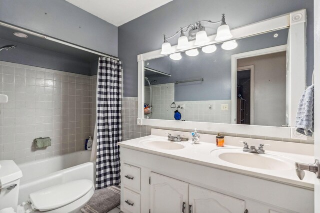 full bathroom featuring vanity, toilet, tile walls, and shower / tub combo with curtain