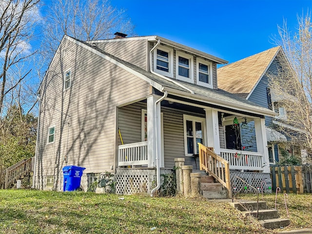 view of front of house with covered porch and a front lawn