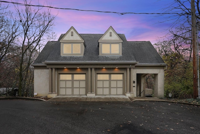 296 Walhalla Rd, Columbus, OH 43202 - view of front of home with stucco siding, a garage, and a shingled roof