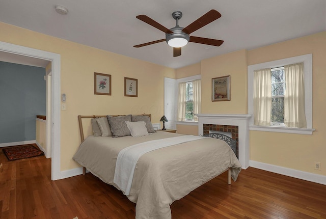 296 Walhalla Rd, Columbus, OH 43202 - bedroom with multiple windows, wood finished floors, a brick fireplace, and a ceiling fan