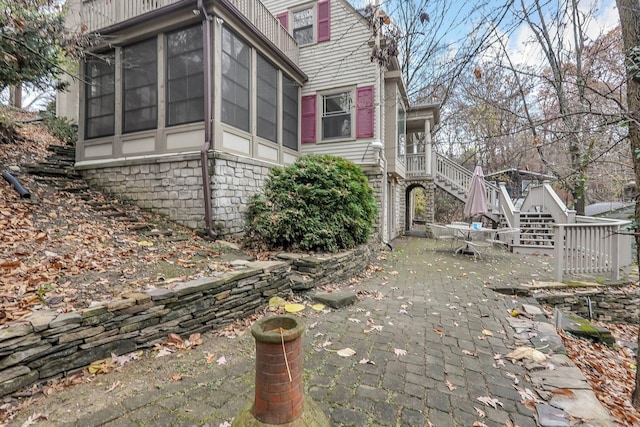 296 Walhalla Rd, Columbus, OH 43202 - view of side of property with stairway, a sunroom, and a patio