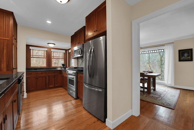 kitchen with decorative backsplash, light hardwood / wood-style floors, and appliances with stainless steel finishes