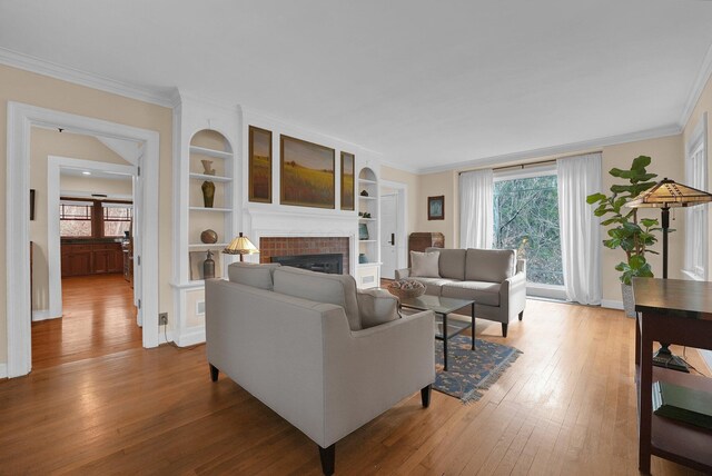 living room with hardwood / wood-style floors, crown molding, and a tile fireplace