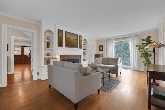296 Walhalla Rd, Columbus, OH 43202 - living room featuring crown molding, a fireplace, healthy amount of natural light, wood finished floors, and built in features