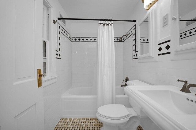 full bathroom featuring shower / tub combo with curtain, toilet, sink, and tile walls