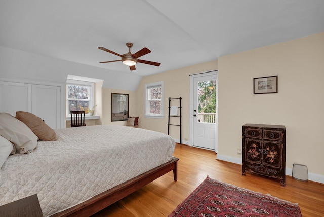 bedroom with access to outside, ceiling fan, vaulted ceiling, and light wood-type flooring