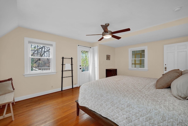 bedroom with multiple windows, wood-type flooring, ceiling fan, and lofted ceiling