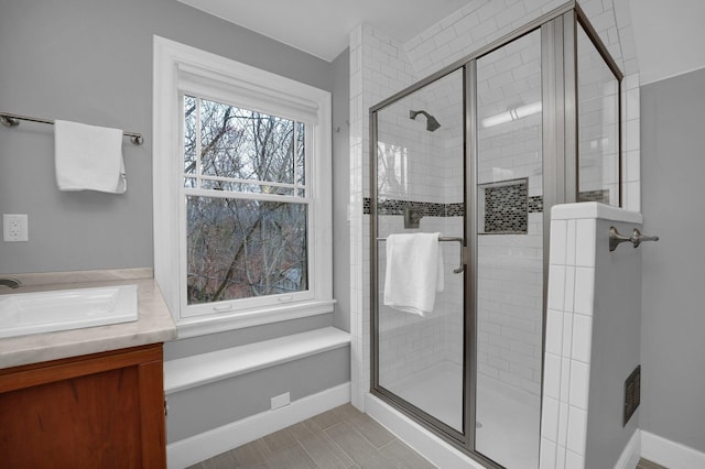 bathroom featuring a shower with door and vanity