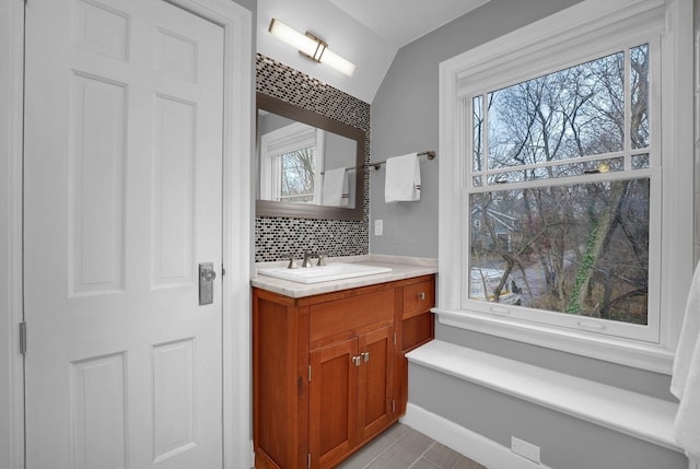 296 Walhalla Rd, Columbus, OH 43202 - bathroom with vanity, backsplash, plenty of natural light, and lofted ceiling