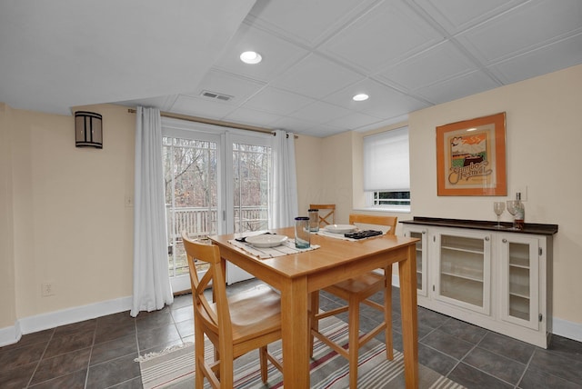 dining space with dark tile patterned floors