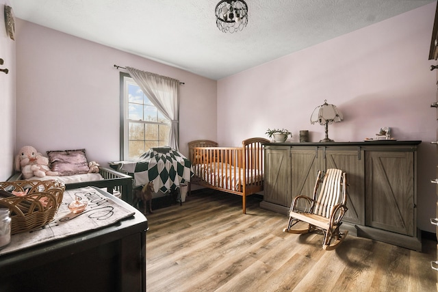 bedroom featuring wood-type flooring and a textured ceiling