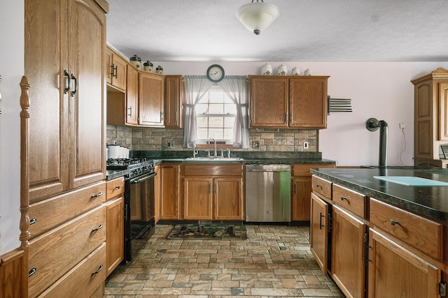 kitchen with tasteful backsplash, stainless steel dishwasher, a textured ceiling, gas stove, and sink