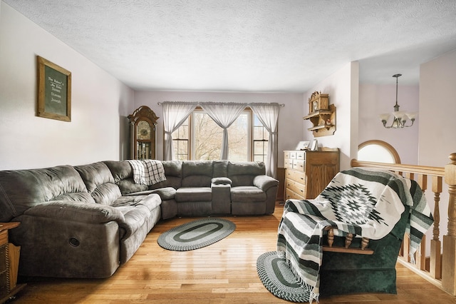 living room with a textured ceiling, hardwood / wood-style flooring, and a notable chandelier